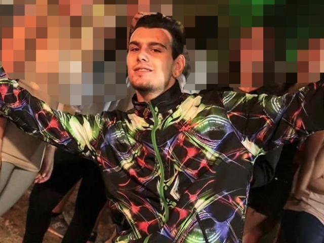 Alessio Martini con indosso il giubbotto multicolore utilizzato nella notte dell'aggressione (foto da Facebook)